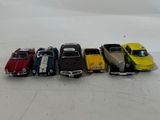 several toy cars are lined up in a row on a white surface
