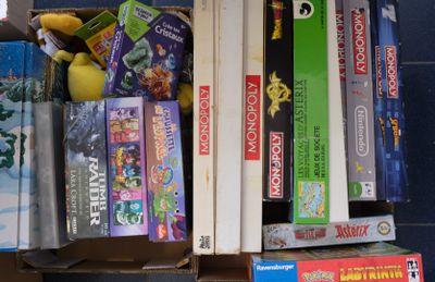 une boîte remplie de jeux, avec une peluche posée dessus
