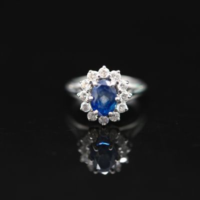 a blue sapphire and diamond ring on a black surface