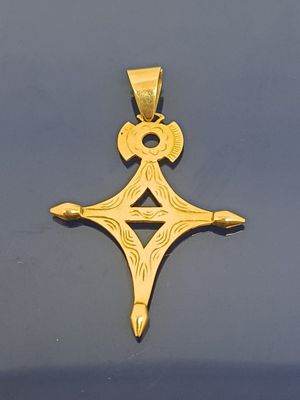 gros plan d'une croix en or sur une surface noire