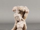une vieille figurine représentant une femme tenant un parapluie au-dessus de sa tête