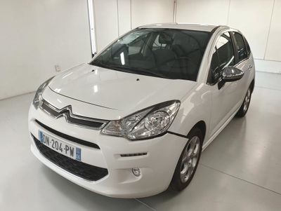 la petite voiture blanche est garée dans une grande pièce