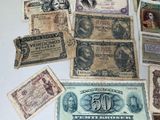 many different types of old paper money on the table