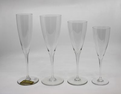trois verres à vin vides posés l'un à côté de l'autre sur une surface blanche
