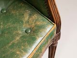 a green leather chair with buttons on the back of it