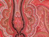 une photo montrant un gros plan d'un tissu à motifs paisley rouges et marron