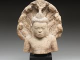 a stone head of a woman with a bird on her head