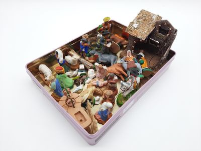 toy figurines in a tin container on a white surface