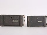 pair of brown leather suitcases sitting on top of a white surface