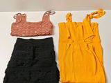trois vêtements posés sur une table blanche
