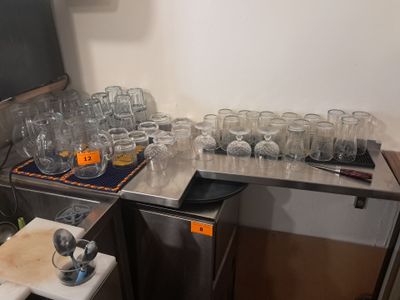 il y a beaucoup de verres vides sur le plan de travail de la cuisine
