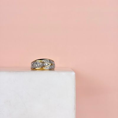 a close up of a gold and diamond ring on a white marble block