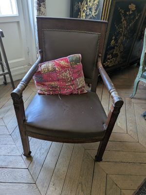 a brown chair with a pillow on it in a room