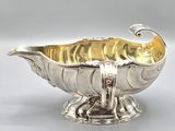 an antique silver plated bowl with a curved handle on a pedestal