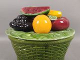 un panier vert rempli de fruits posé sur une table