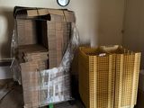 une pile de cartons dans un coin d'une pièce où est accrochée une horloge au mur