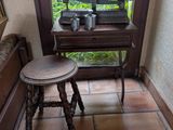 a small table and stool in the corner of a room
