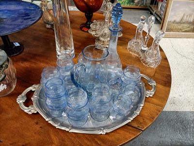 des bouteilles et des verres posés sur un plateau, sur une table, dans un magasin