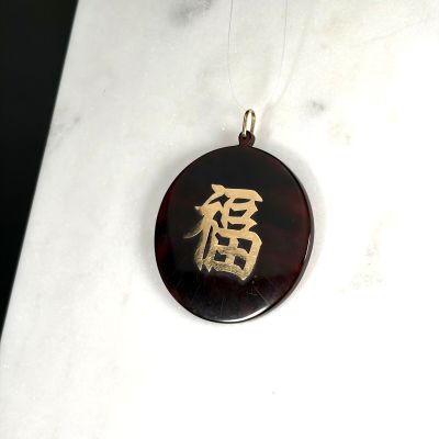 une photo d'un collier sur lequel figure un caractère chinois