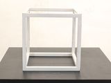a white box on a black table with a white wall in the background
