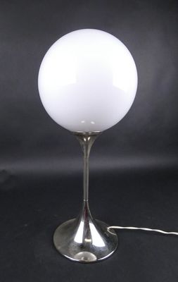 une photo d'une lampe de table sur laquelle est posée une boule en verre blanc