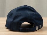 the hat is blue and has a metal buckle on the front