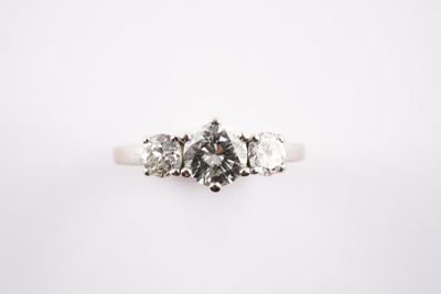 a close up of a three stone diamond ring on a white background