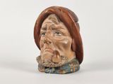 une figurine en céramique représentant un homme coiffé d'un chapeau