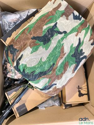 une boîte en carton contenant divers objets, dont un sac de camouflage