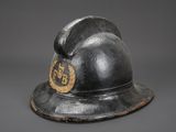 an old fireman ' s helmet with a gold emblem on it