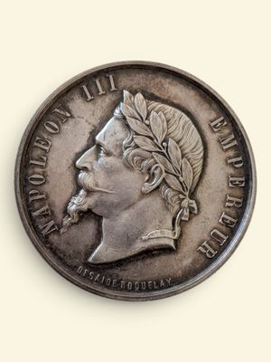 une vieille pièce de monnaie avec un visage d'homme sur une surface blanche