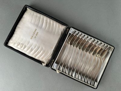 des couverts dans une boîte noire contenant une cuillère et une fourchette en argent