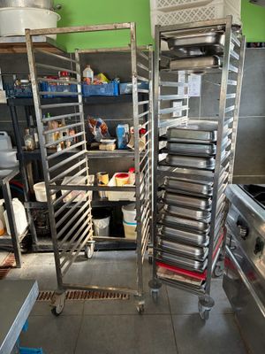 many trays of food that are on a rack in the kitchen