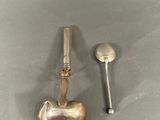 two silver spoons and a spoon rest on a table