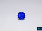 a close up of a blue stone on a white surface