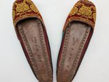 pair of red and gold slippers on white surface