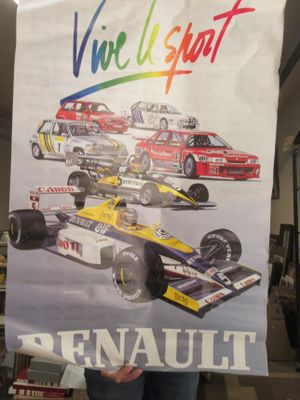un homme tenant une grande affiche sur laquelle figurent plusieurs voitures de course