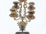 a metal candelab with five candles on a stand