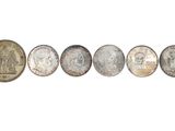 a row of five different coins sitting next to each other
