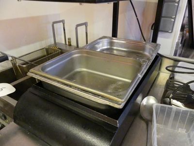 une casserole en métal posée sur une cuisinière dans une cuisine