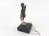 statue en bronze représentant un homme tenant une épée, posée sur un socle noir
