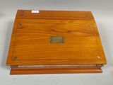 an old wooden box with a label on it sitting on a white surface