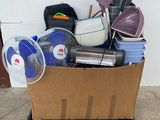 a cardboard box full of household items and a fan