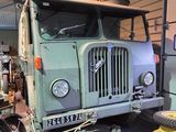 a green truck that is parked in a garage