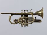 a brass trumpet hanging from the ceiling in a room