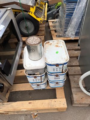 several buckets of water sitting on a pallet next to a microwave