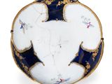 une assiette blanche ornée de motifs bleus et dorés