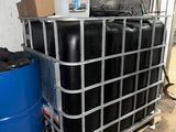 a large metal container with several black barrels in it