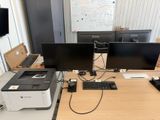 a desk with two monitors and a printer on it