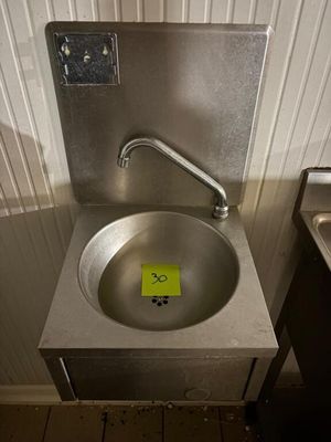 un lavabo sur lequel est collé un autocollant jaune, dans une salle de bains